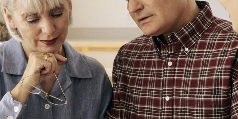 professionals explaining terms to an old couple